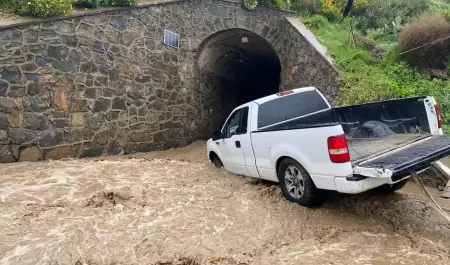 Rescatan a persona de su vehículo atascado en arroyo de Rosarito