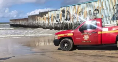 Unidad de bomberos en muro fronterizo en Playa de Tijuana