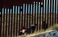 Migrantes que lograron cruzar a EU esperan comida de Mxico junto al muro