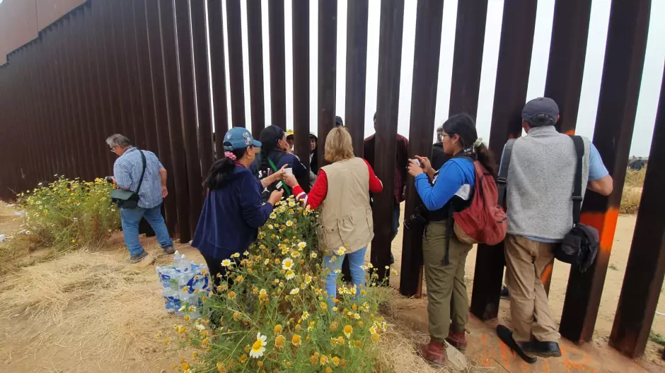 Migrantes en el muro fronterizo