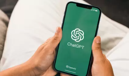 Mano femenina sosteniendo un smartphone con la aplicaci�n de chatbot de intelige