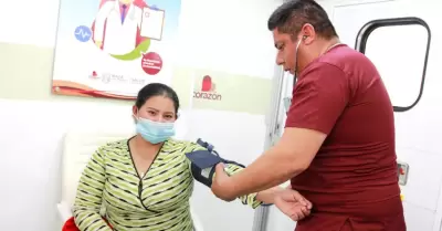 Médico revisando la presión de una paciente