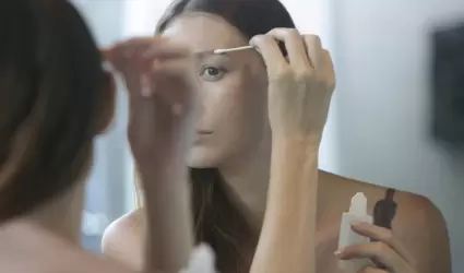 Mujer frente al espejo realizando rutina de Skincare