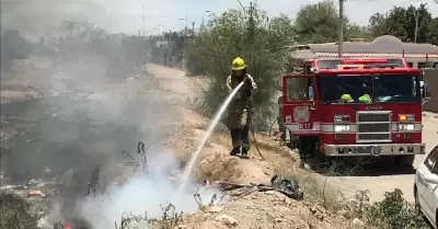 Bomberos atendiendo incendio de maleza