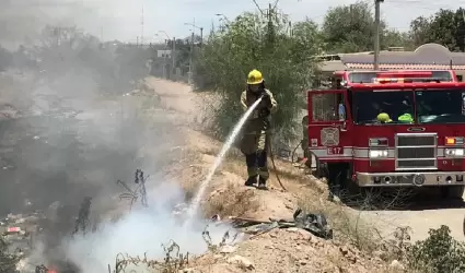 Bomberos atendiendo incendio de maleza