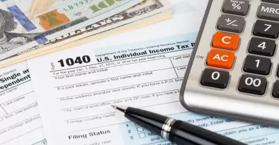 Formulario de impuestos con billete de calculadora, pluma y dlar