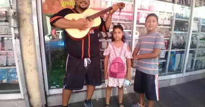 Nios acompaados de su padre cantan en calles del Centro para recaudar dinero y