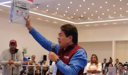 Mario Delgado muestra uno de los paquetes de la encuesta de Morena