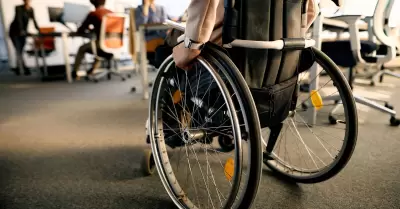 Mujer en silla de ruedas mientras pasa por la oficina