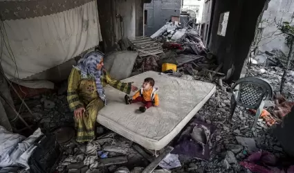 Una mujer palestina y su hijo, en el interior de una casa bombardeada en Gaza.