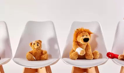 Tres juguetes de peluche sobre sillas en la sala de espera de un moderno hospita