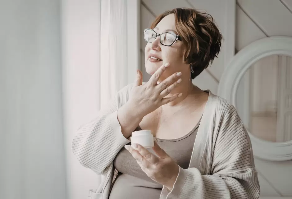 Mujer aplicando su rutina de cuidado de la piel